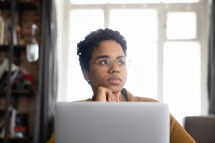 A person with a serious expression at a laptop.