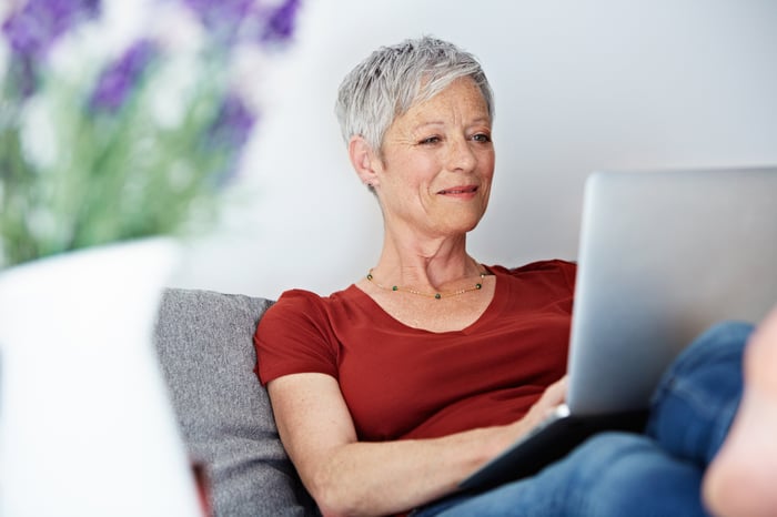 Smiling person using laptop.