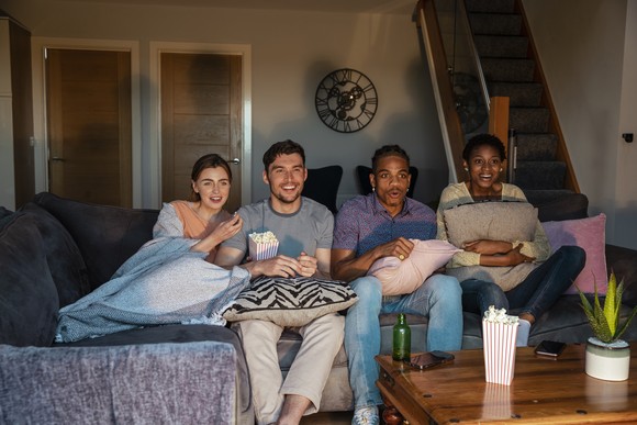 A group of friends watching a movie at someone's house.