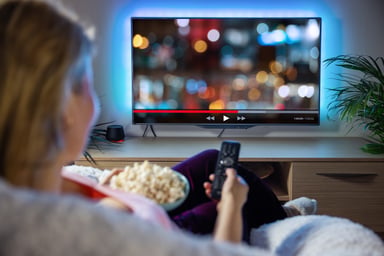 woman streaming on tv with popcorn