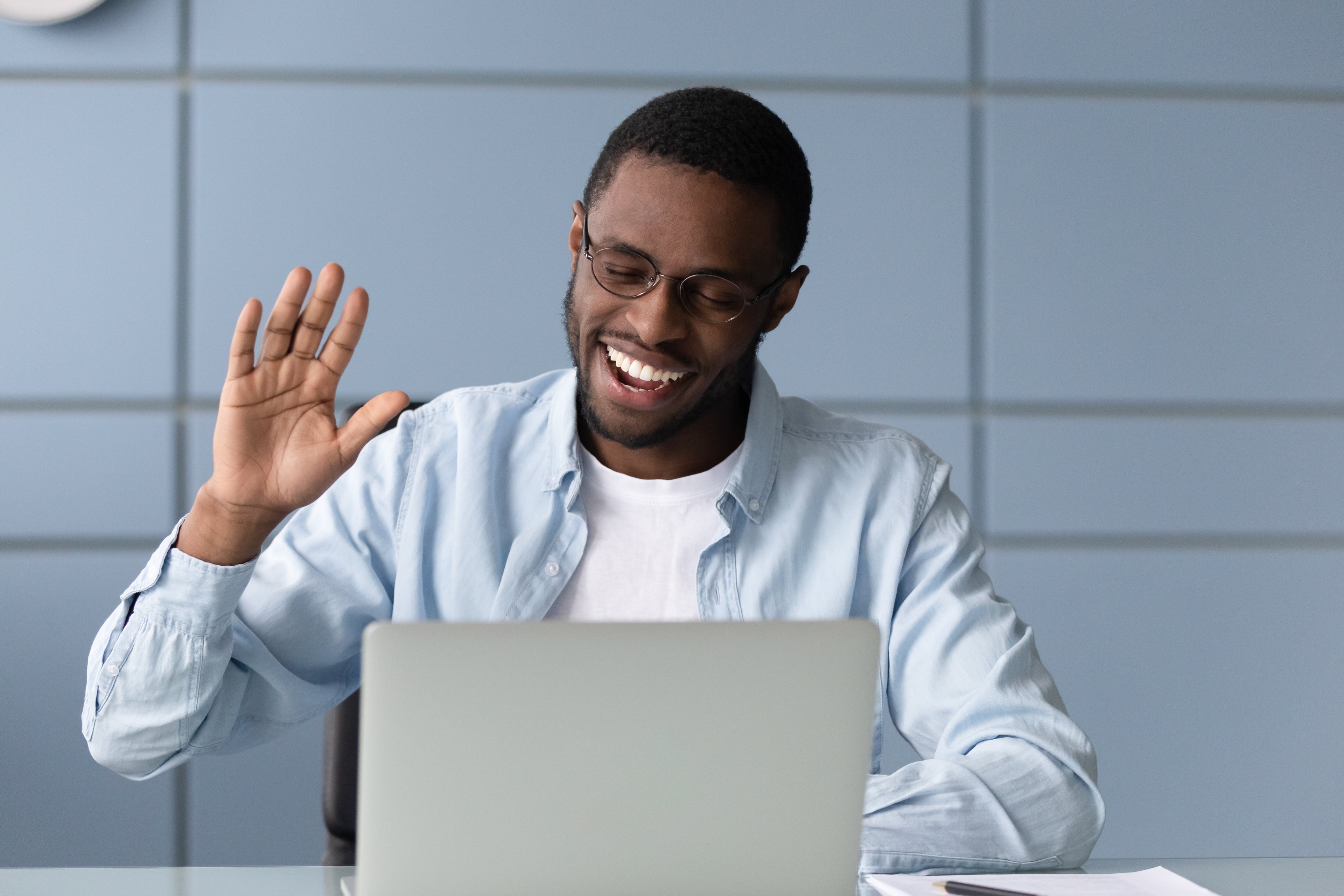 A person waving to a friend on a video call.