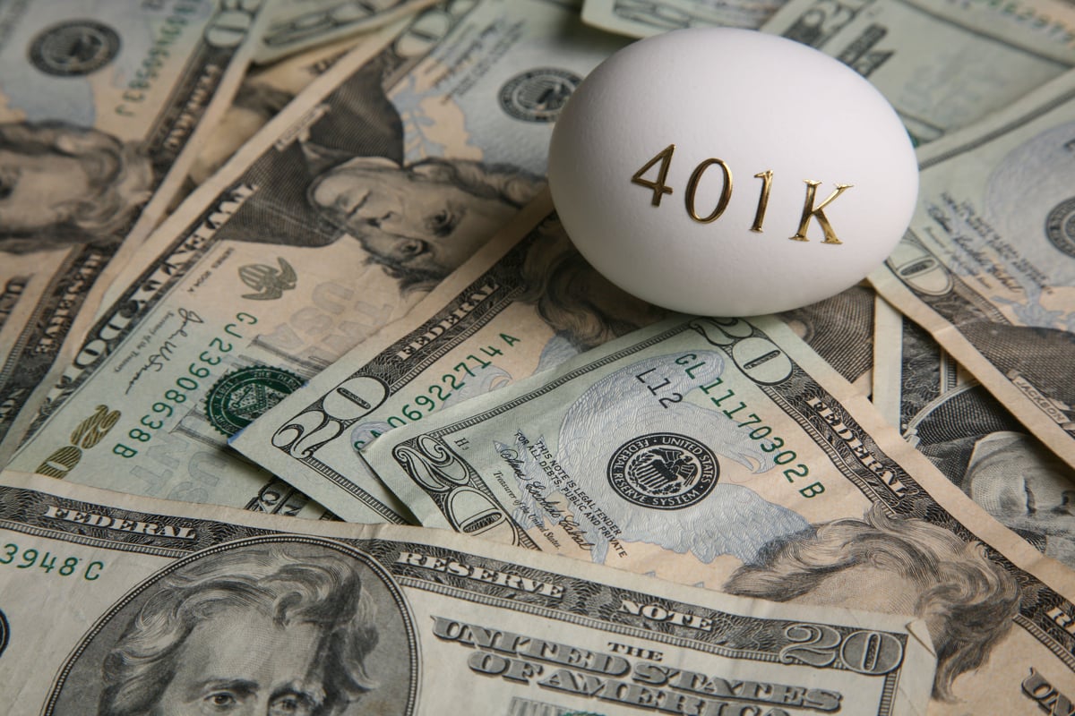 An egg with the word 401k printed on it lying on top of $20 bills.