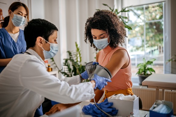 A doctor checking the blood pressure of a patient.