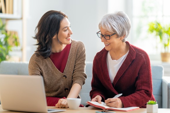Two people sit at a table and smile.