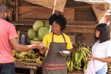 A person selling bananas in an outdoor stall