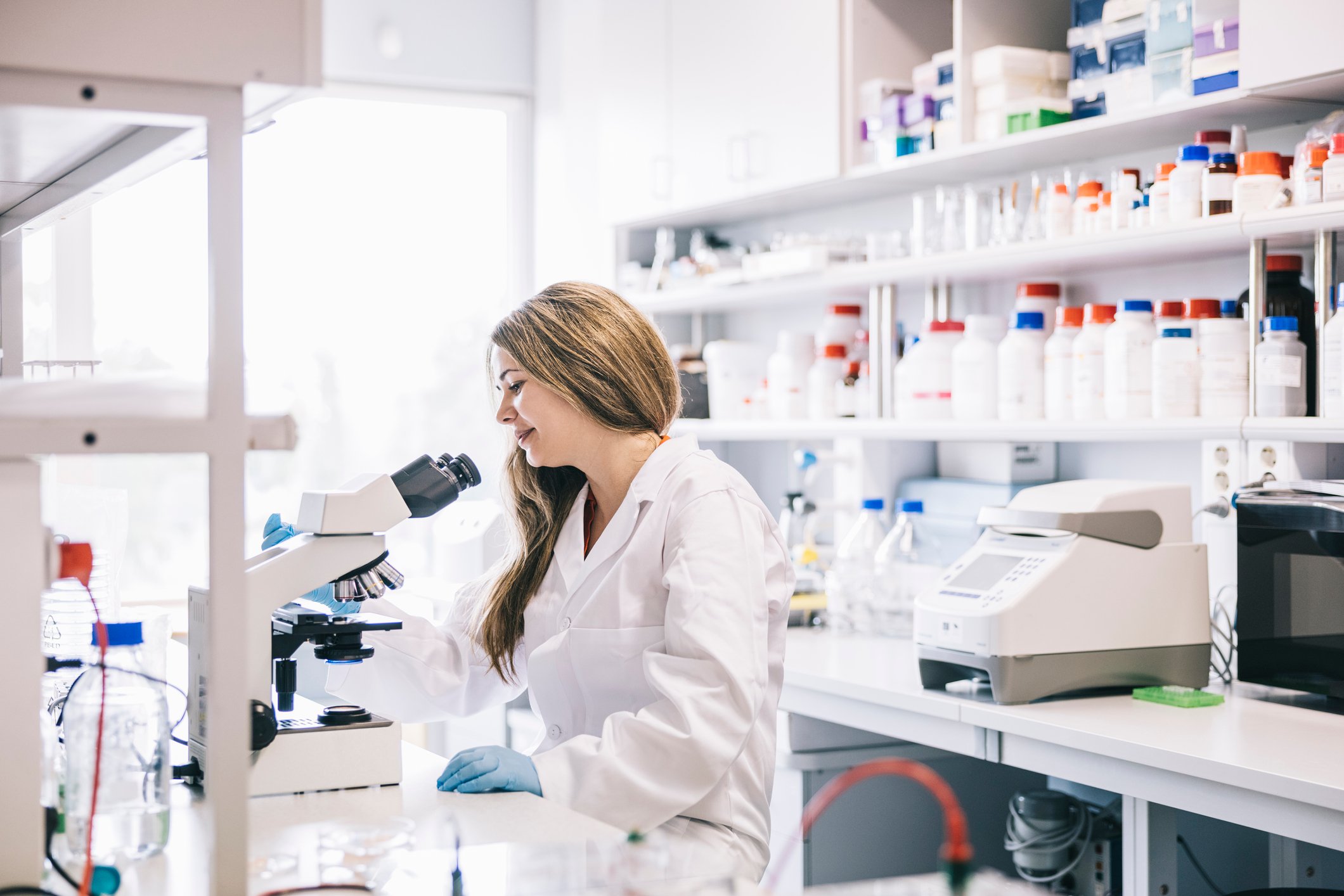Female scientist observing with microscope