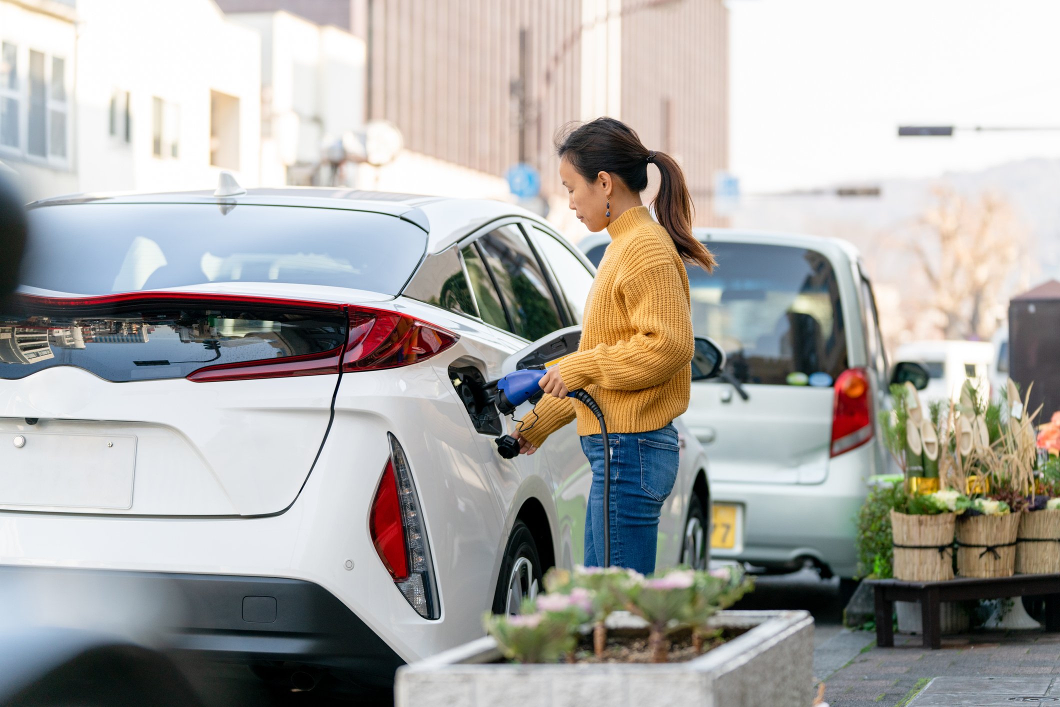 A person plugging a charger into an electric car