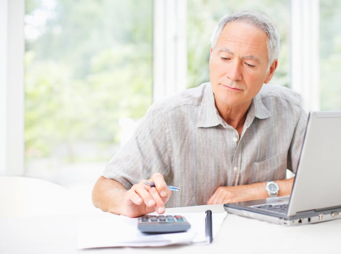 A person at a laptop using a calculator.