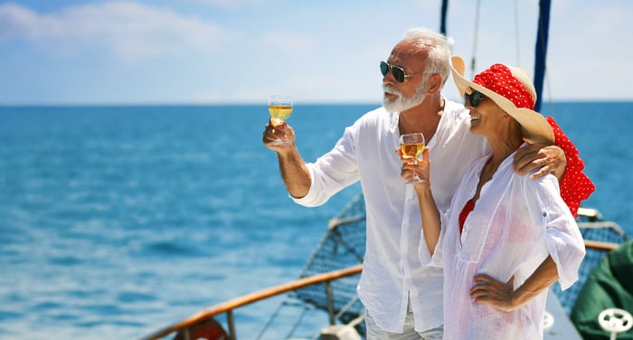 Two people on a boat holding wine glasses.