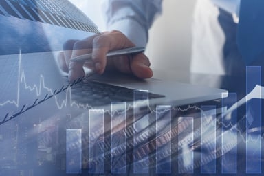 A hand on a laptop with a bar chart.