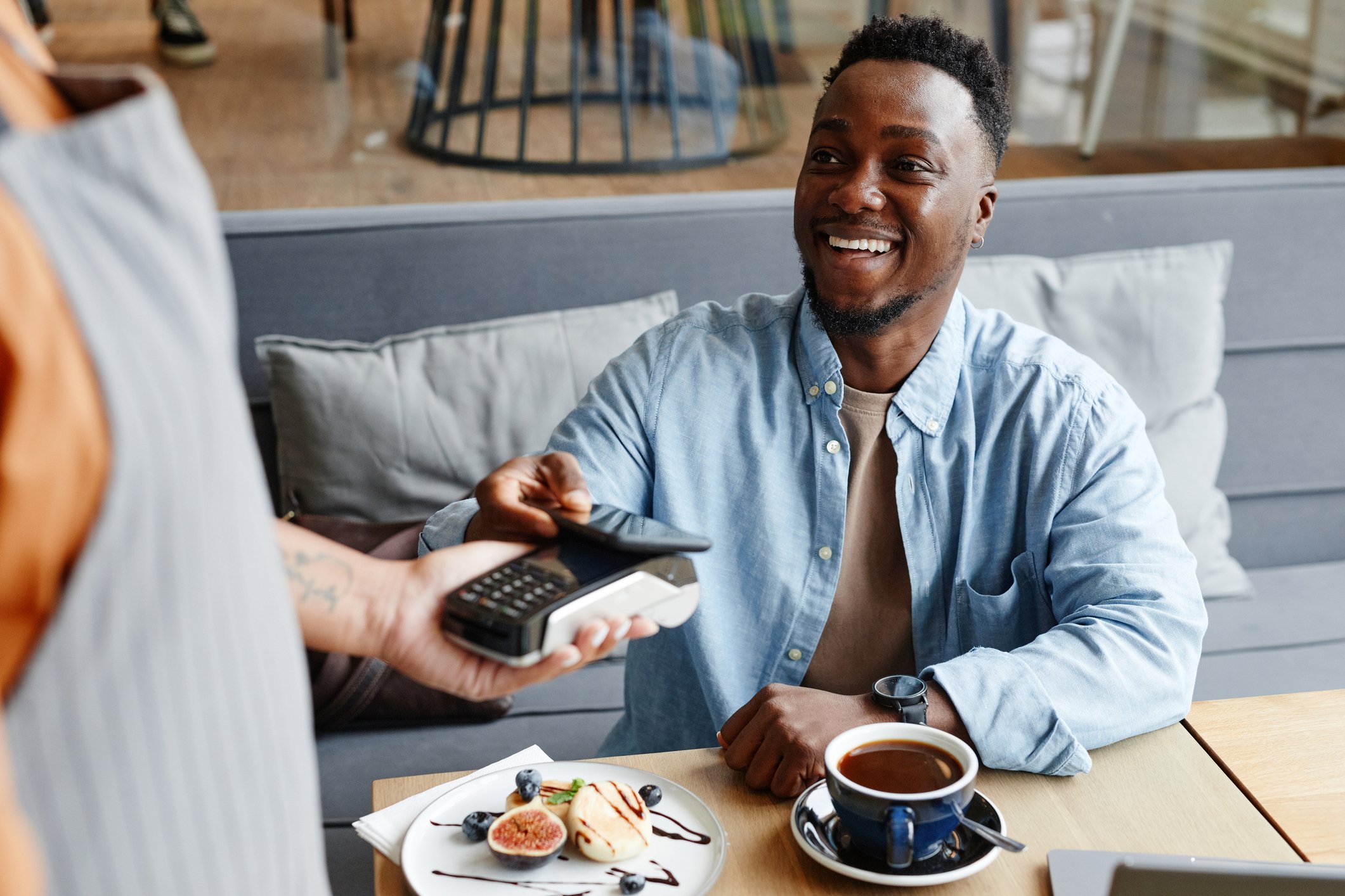 A person using their phone to pay a bill at a restaurant.