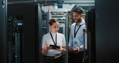 Two colleagues working together in a server room