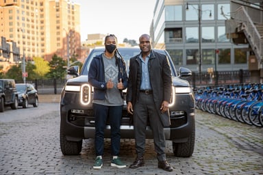 Rivian on city street with owners