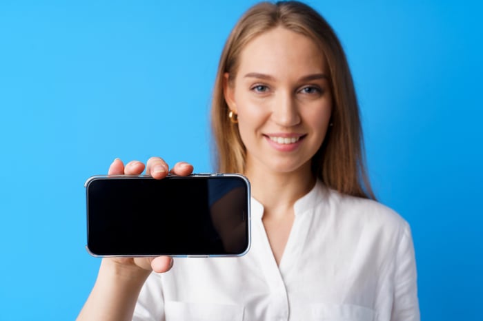 A customer holding up a mobile phone. 