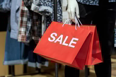 Big red bag reads SALE in a clothing store.