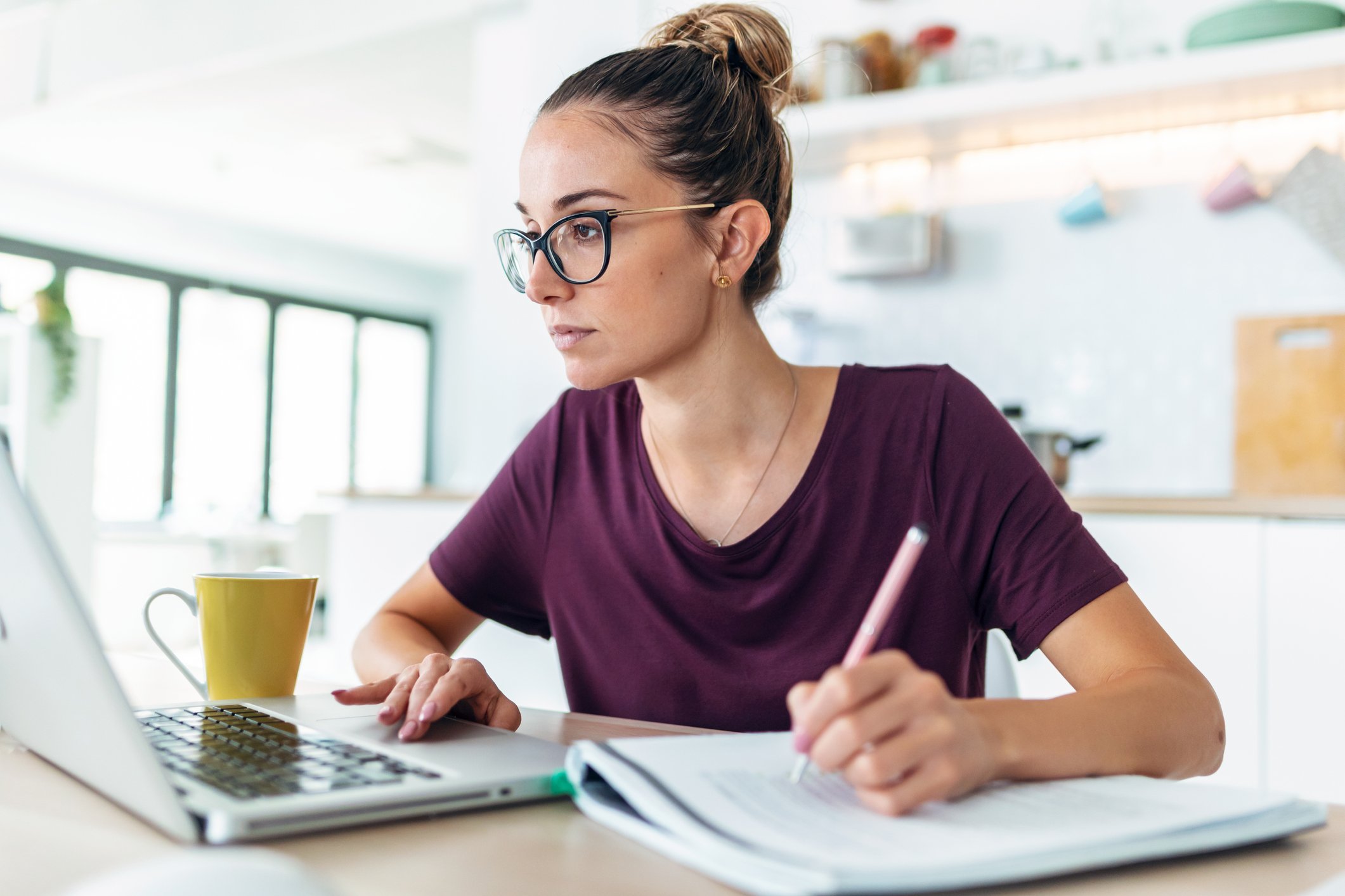 A person at a laptop taking notes.