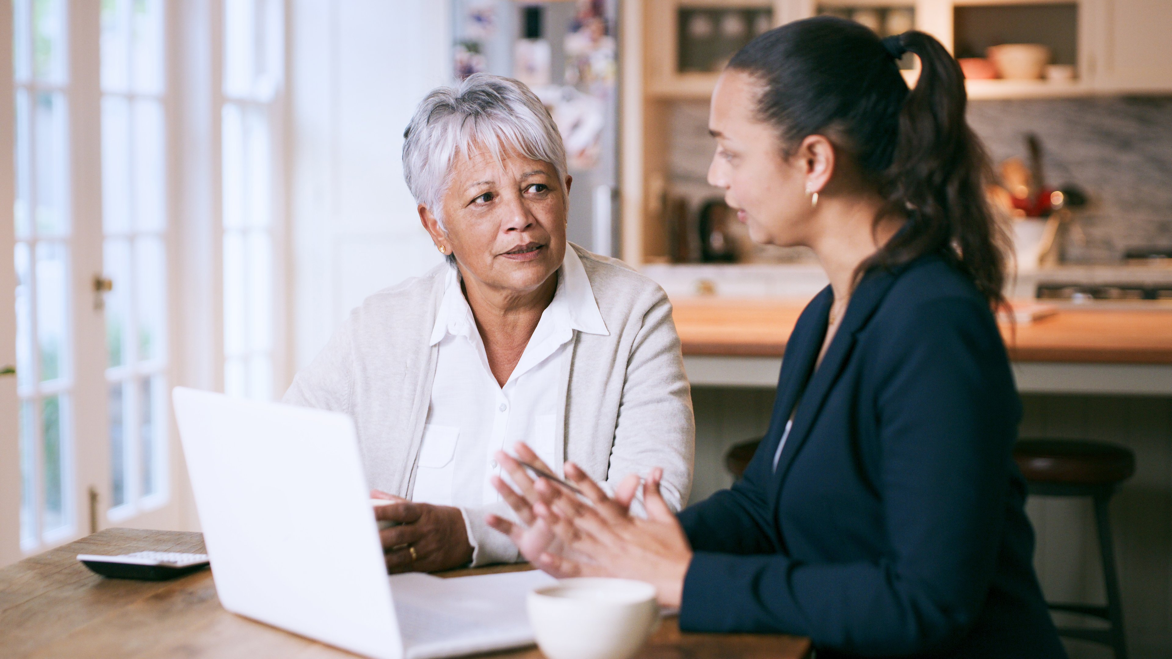 Two adults looking at laptop and calculator.