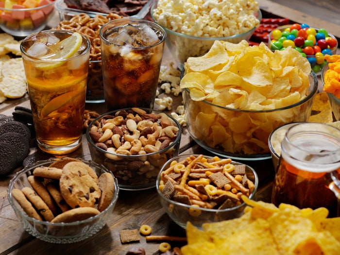 Bowls of snack food and beverage glasses arranged on a table.