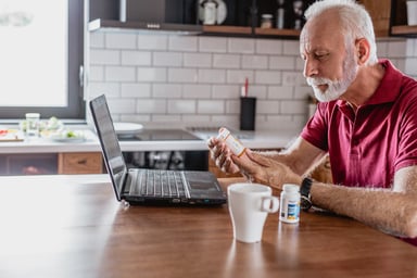 Older man pills laptop_GettyImages-1183769809