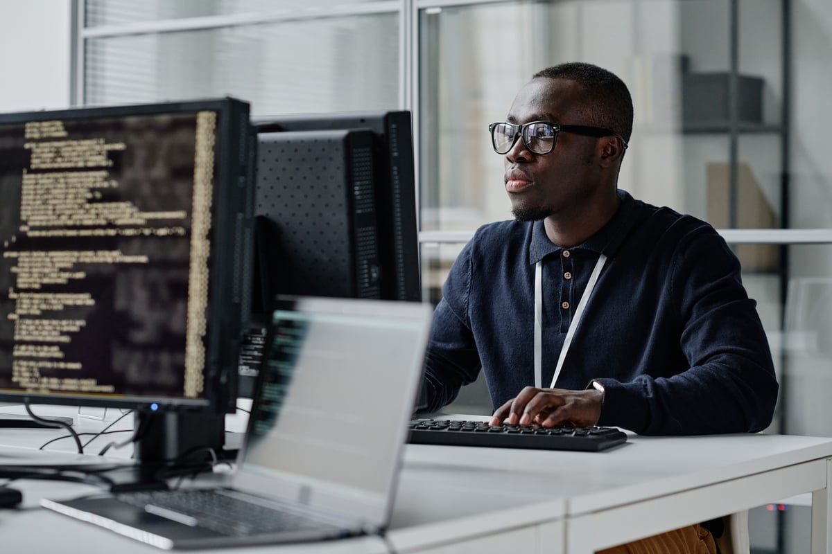 A person coding on a desktop computer.