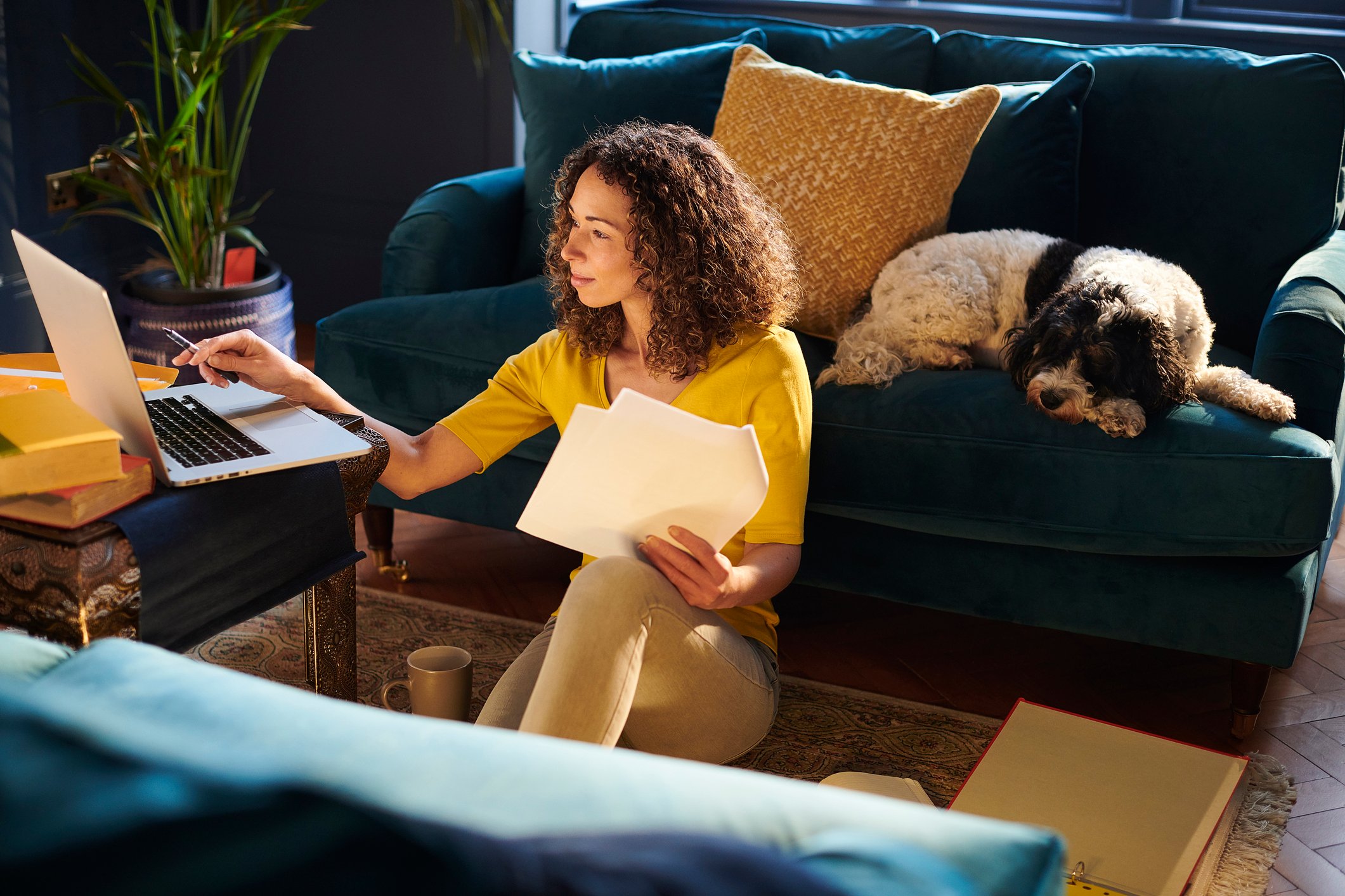 person sitting on the floor looking at a laptop