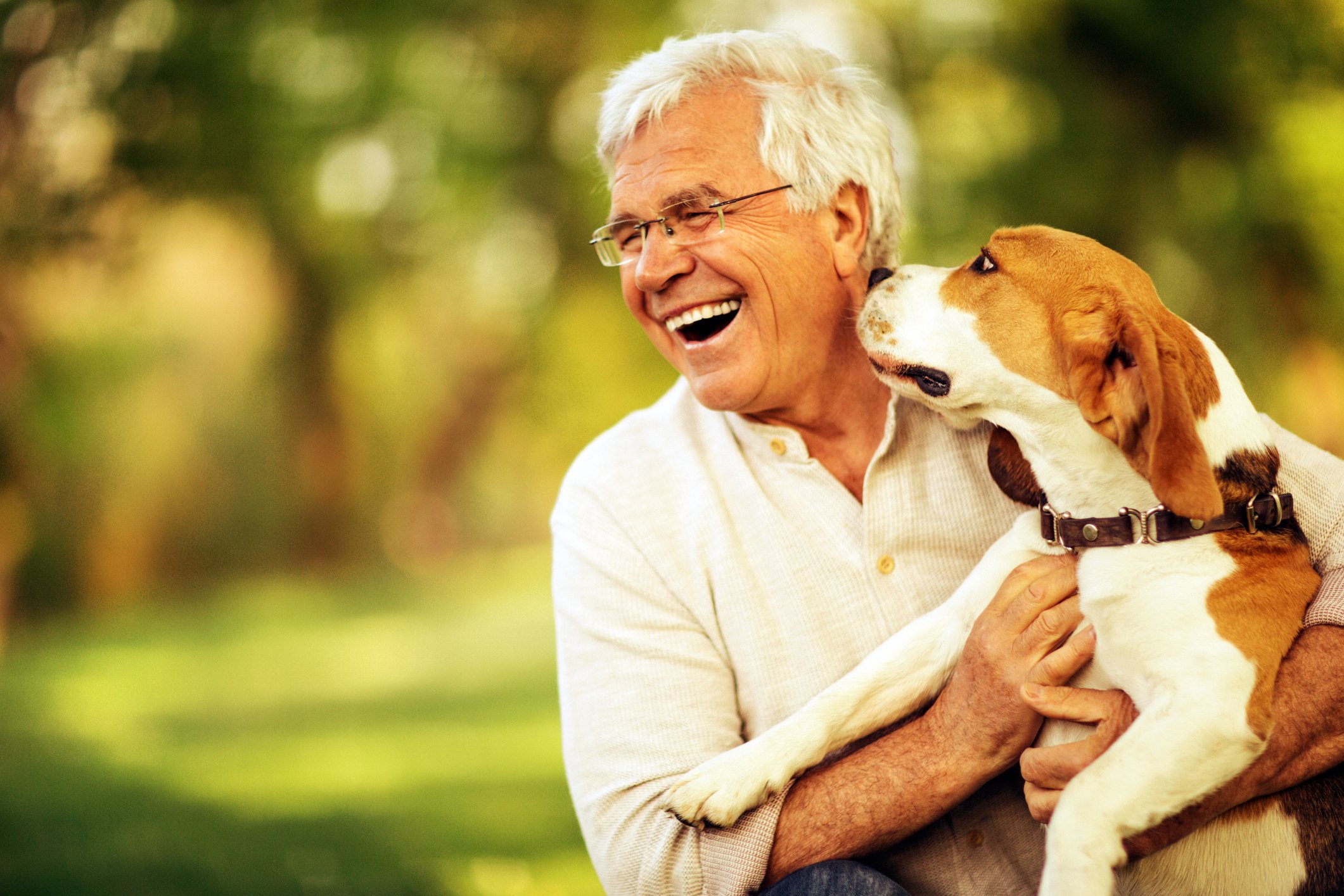 Person smiles with dog in an outdoor setting