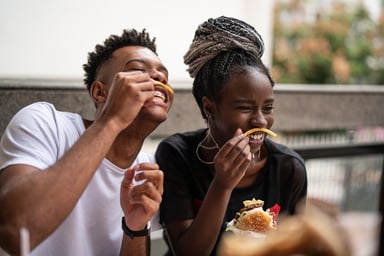 2 people eating burgers fries fast food