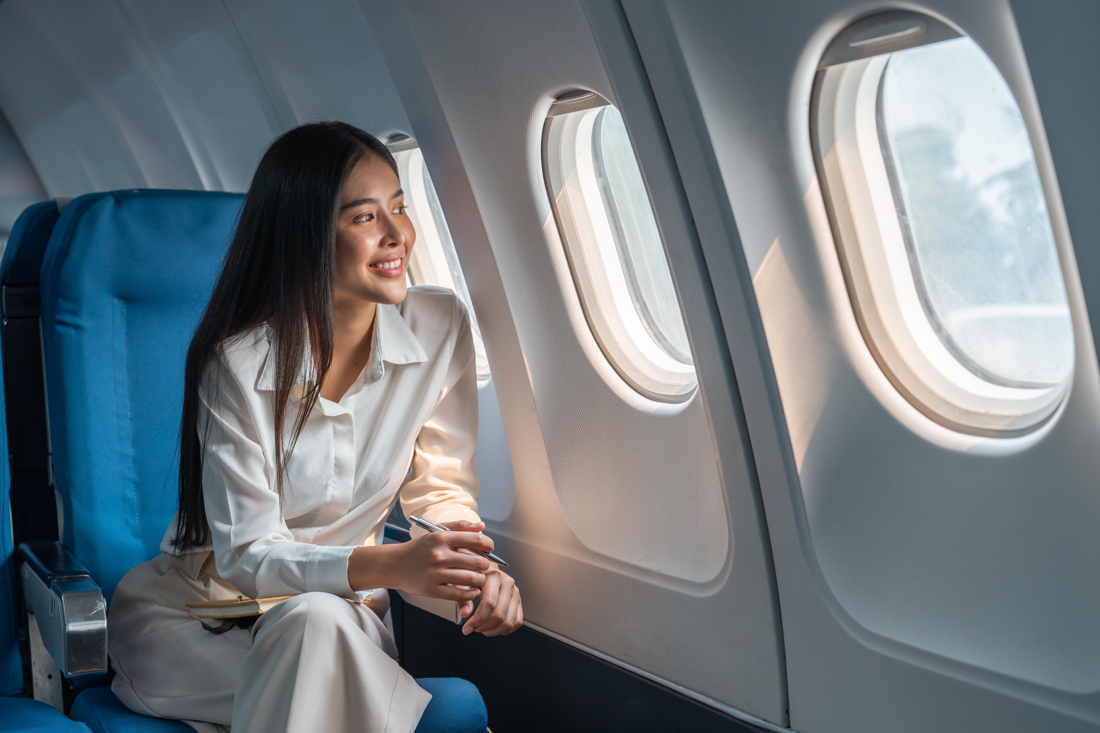 An airplane passenger looks out a window.