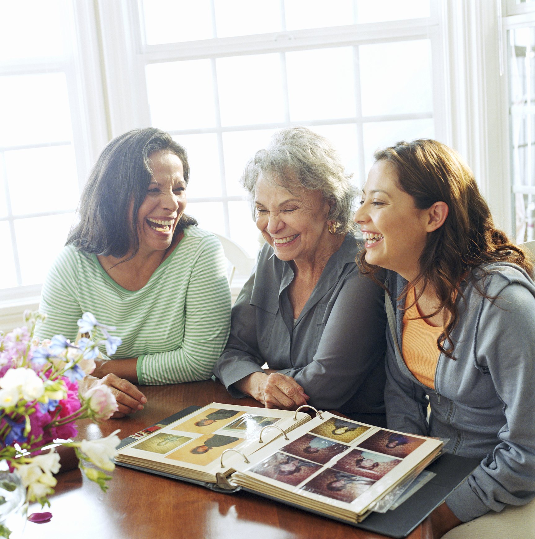 Three people looking at a photo album.