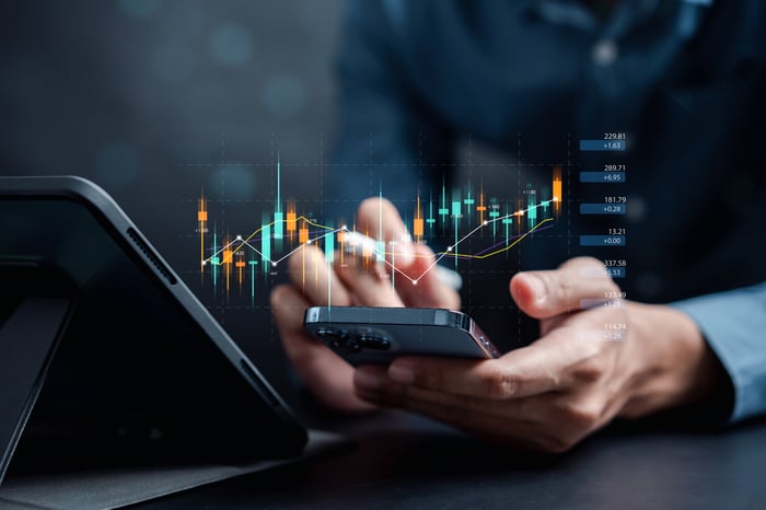 Individual Checking Financial Charts On Their Mobile Phone