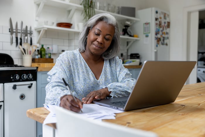 A person at a laptop writing.