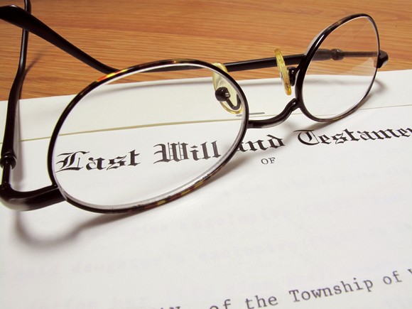 A pair of glasses atop a will document.