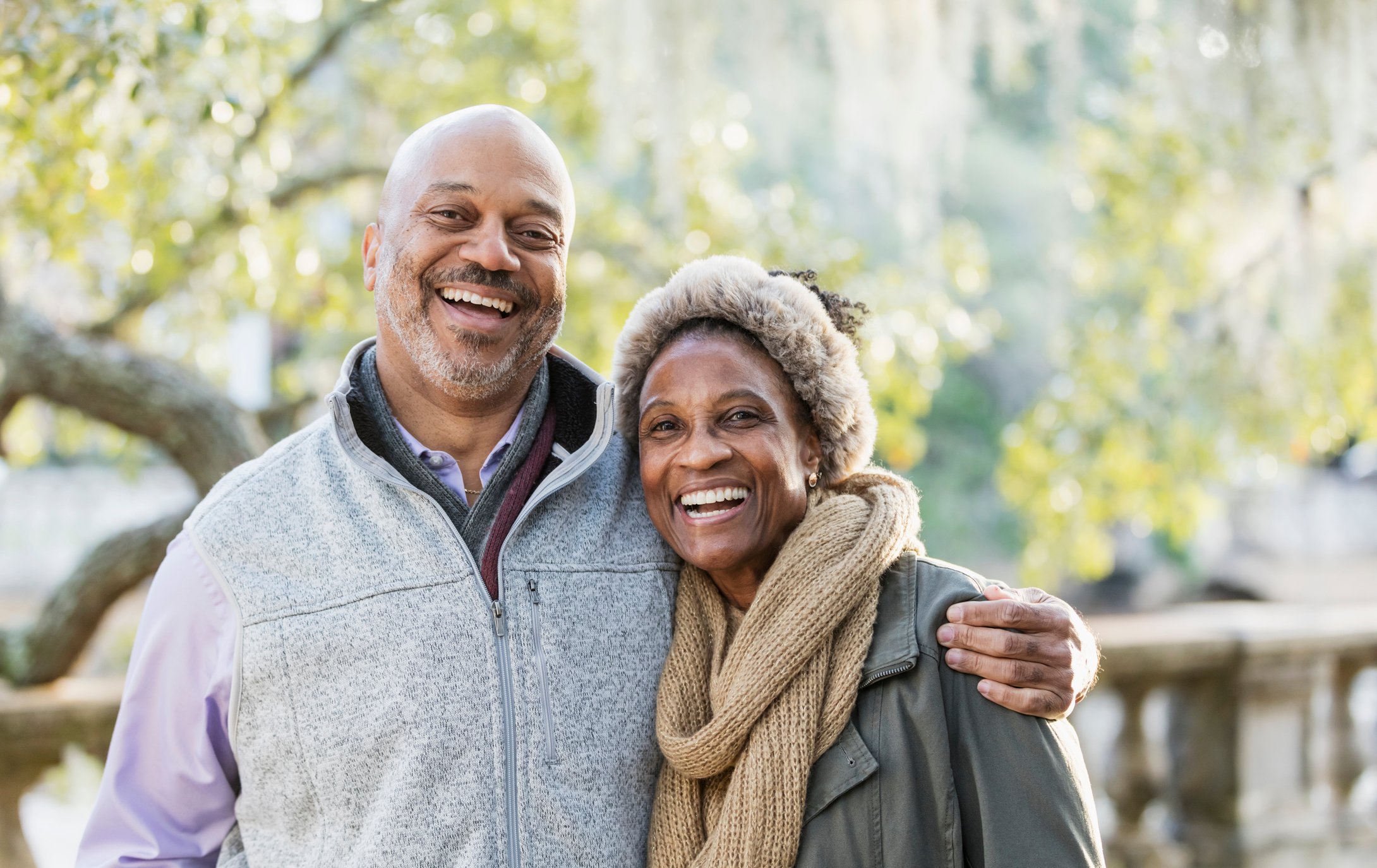 Two smiling people outdoors.
