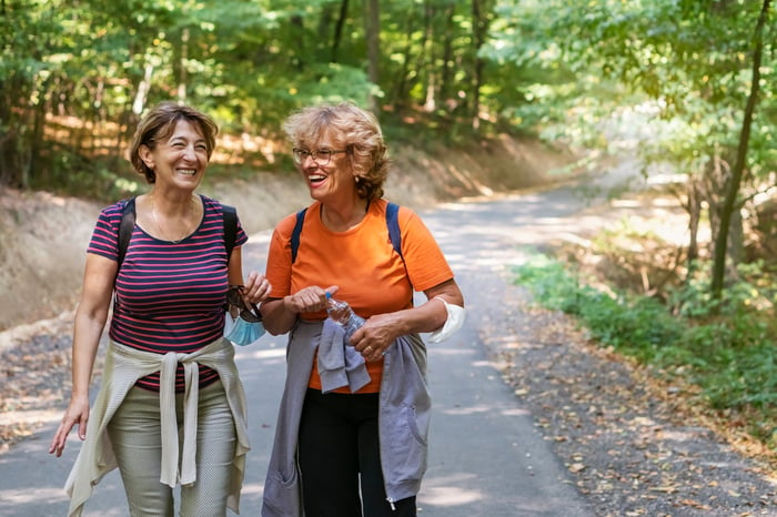 Two smiling people out for a hike.