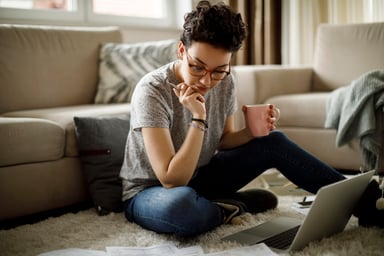 Person sitting on floor looking at documents
