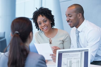 Couple talking to loan officer bank branch getty