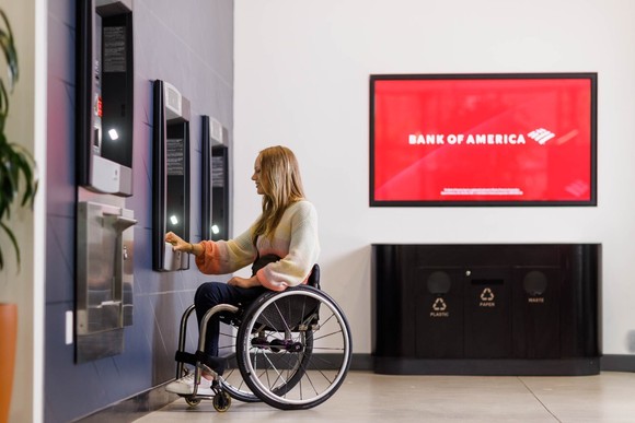 A woman in a wheelchair at a Bank of America ATM.