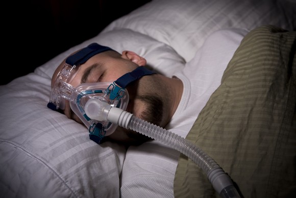 A person sleeping with a CPAP machine.