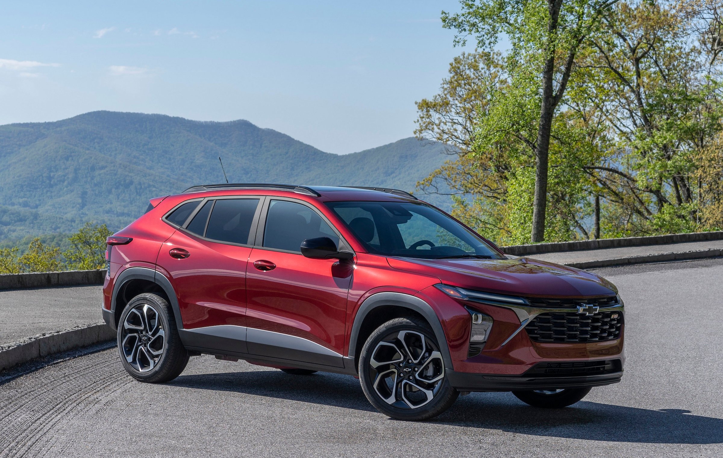 A red Chevrolet Trax, a small internal-combustion crossover, parked on a scenic overlook. 