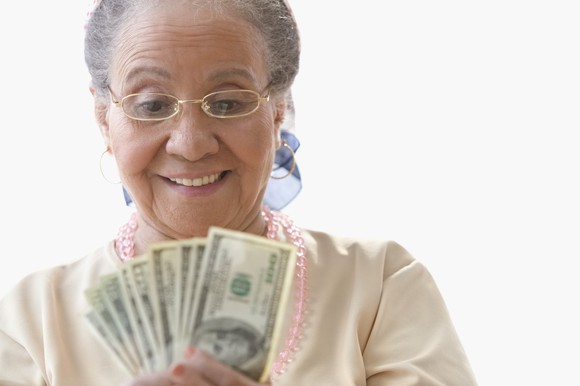 A smiling person looking at cash.