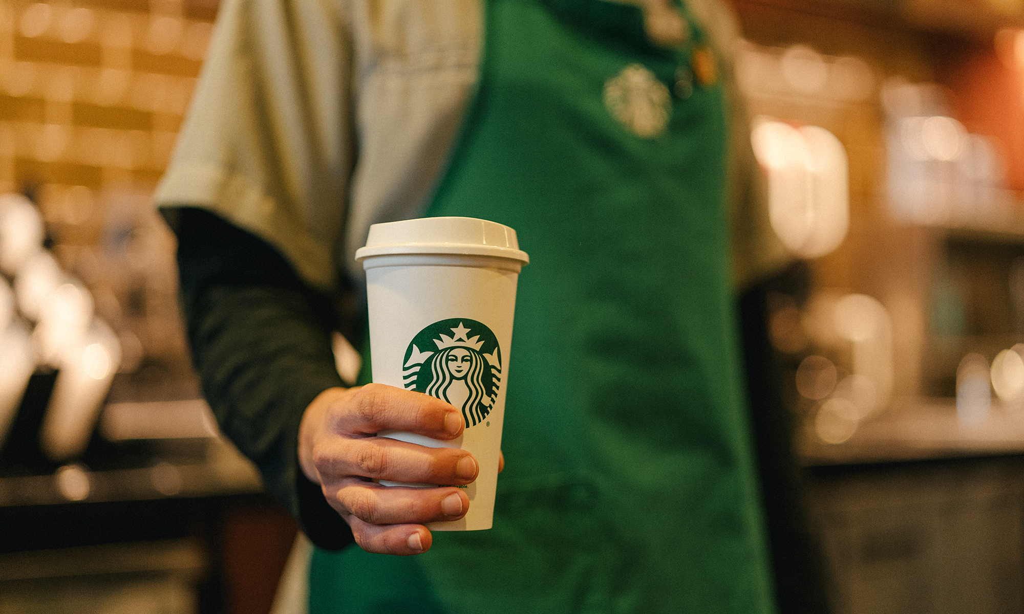 A barista serves a cup of coffee.