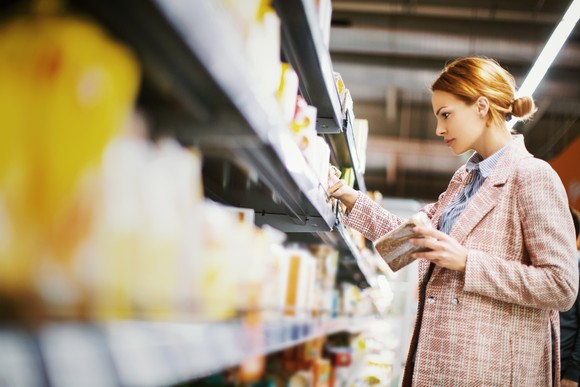 A shopper takes products from a shelf.