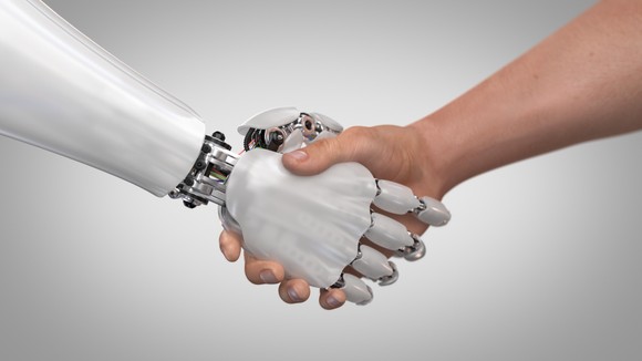 A human and robot shaking hands.
