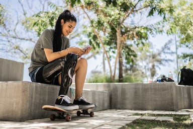 A woman with a skateboard looking at a phone