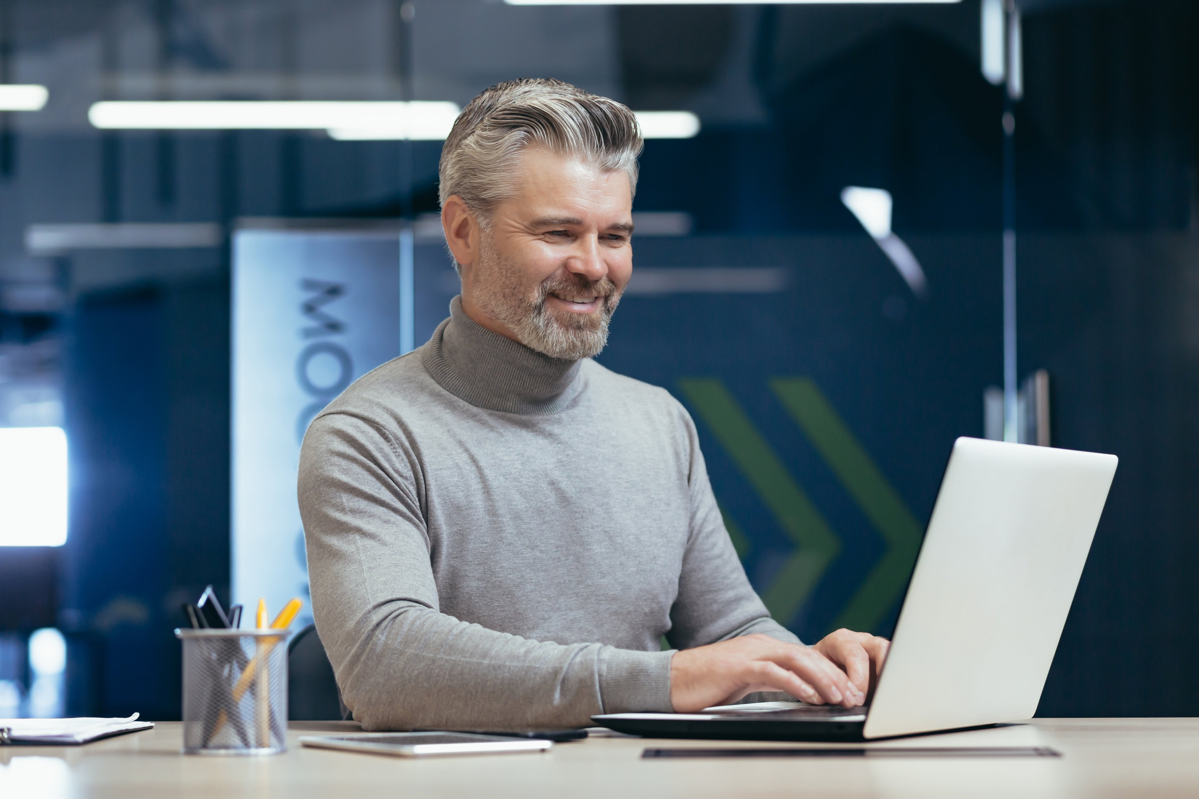 smiling investor typing on laptop