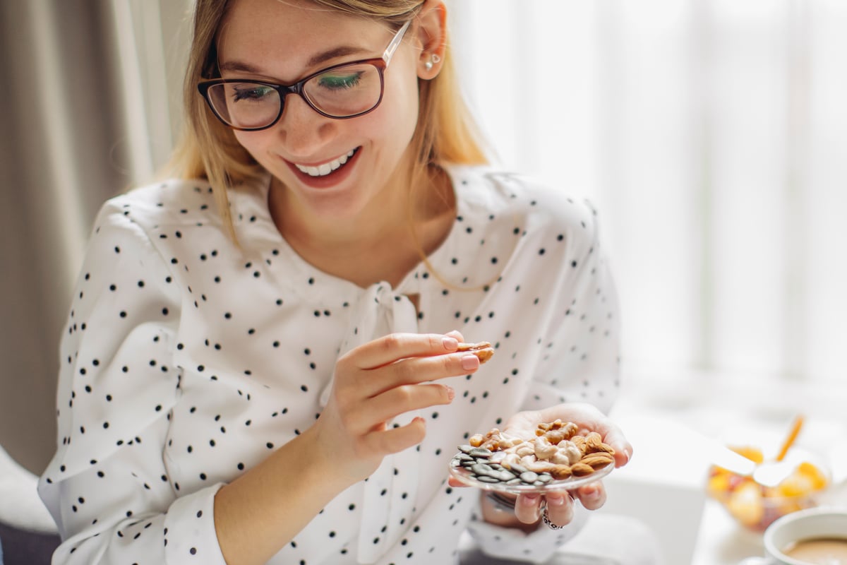 A woman wearing glasses and eating breakfast