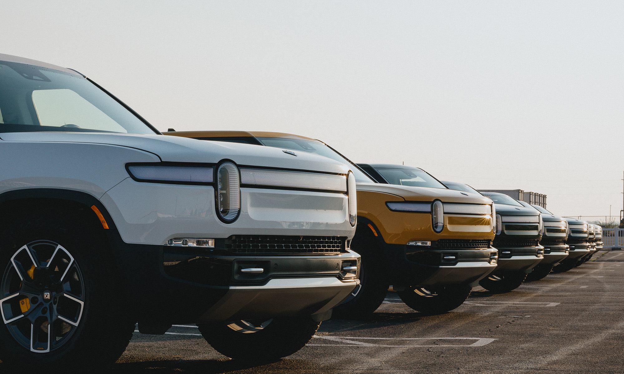 line of _rivian trucks in parking lot_rivian_