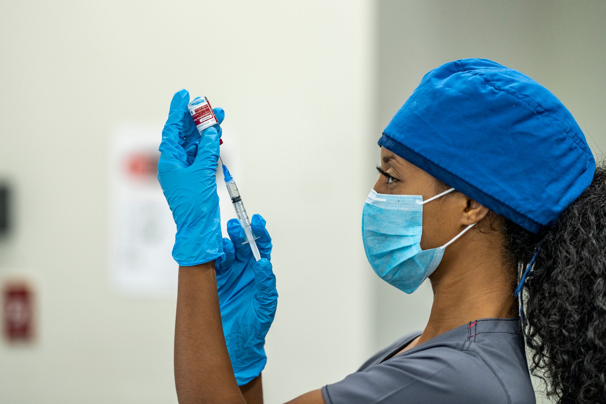 A healthcare worker prepares to administer a vaccine.