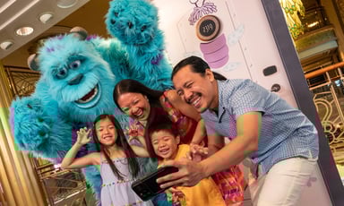 Family taking pictures with a Disney character.