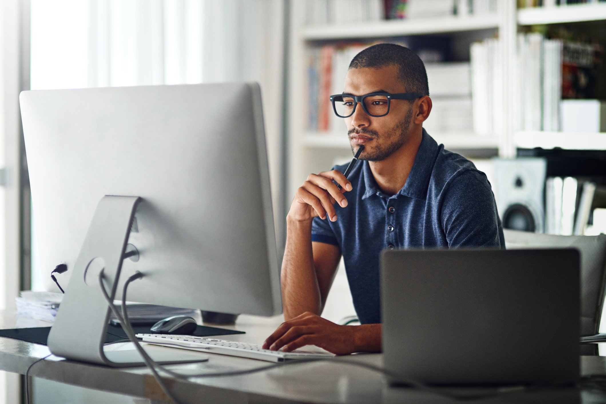 investor sitting at computer with pen
